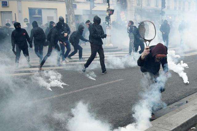 PARÍS (FRANCIA), 22/03/2018.- Manifestantes se enfrentan con la policía antidisturbios durante la huelga general de los servicios públicos y transportes en París (Francia) hoy, 22 de marzo de 2018. La huelga podría poner a prueba las reformas emprendidas por el presidente Emmanuel Macron. EFE/ Yoan Valat