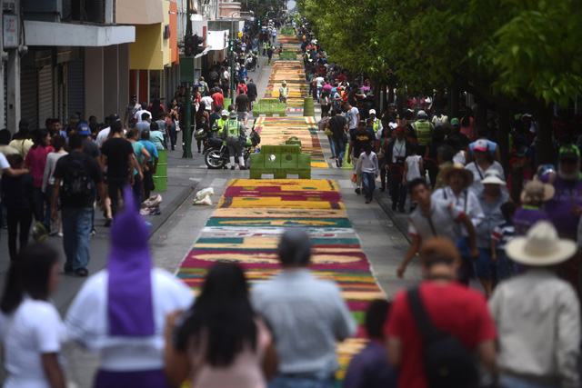GU4007. CIUDAD DE GUATEMALA (GUATEMALA), 29/03/2018.- Voluntarios guatemaltecos participan en la elaboración de una alfombra de serrín hoy, jueves 29 de marzo de 2018, durante la celebración del Jueves Santo en Ciudad de Guatemala (Guatemala). Miles de guatemaltecos se reunieron este Jueves Santo para elaborar una alfombra de serrín, considerada la más grande del mundo, en el Paseo de la Sexta, la calle peatonal más emblemática del centro histórico de la capital. Los 1.200 voluntarios, convocados por la Municipalidad metropolitana, empezaron hoy a hacer esta alfombra de más de 2.000 metros de longitud y en la que se emplearon un millar de sacos de serrín. EFE/Edwin Bercían