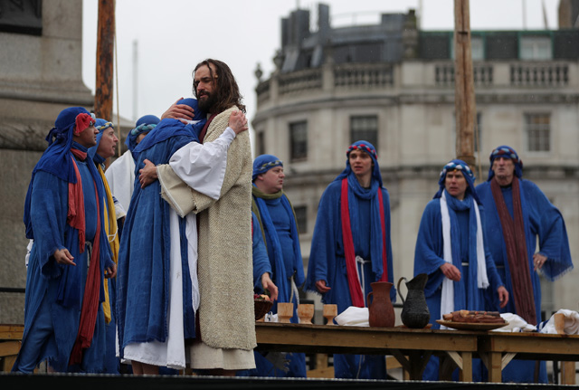 Actor James Burke-Dunsmore (3L) plays the role of Jesus Christ, during a performance of Wintershall's 'The Passion of Jesus' on Good Friday in Trafalgar Square in London on March 30, 2018.  The Passion of Jesus tells the story from the Bible of Jesus's visit to Jerusalem and his crucifixion. On Good Friday 20,000 people gather to watch the Easter story in central London. One hundred Wintershall players bring their portrayal of the final days of Jesus to this iconic location in the capital. / AFP PHOTO / Daniel LEAL-OLIVAS