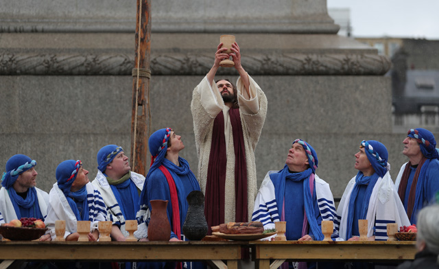 Actor James Burke-Dunsmore (C) plays the role of Jesus Christ, during a performance of Wintershall's 'The Passion of Jesus' on Good Friday in Trafalgar Square in London on March 30, 2018.  The Passion of Jesus tells the story from the Bible of Jesus's visit to Jerusalem and his crucifixion. On Good Friday 20,000 people gather to watch the Easter story in central London. One hundred Wintershall players bring their portrayal of the final days of Jesus to this iconic location in the capital. / AFP PHOTO / Daniel LEAL-OLIVAS