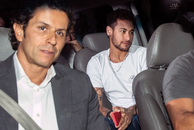 (FILES) In this file photo taken on March 02, 2018 Brazilian superstar Neymar (R), is pictured next to his doctor Rodrigo Lasmar (L), upon his arrival in Belo Horizonte, Minas Gerais state, Brazil, ahead of an operation on his fractured foot. Neymar and Manuel Neuer, Brazil's best player and the German captain of world champion team, will they be recovered in time for the World Cup 2018 ? That's the question arising for two of the competition's favourites. / AFP PHOTO / NELSON ALMEIDA