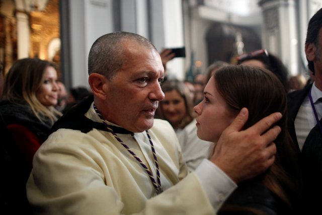 Spanish actor Antonio Banderas and his daughter Estela del Carmen talk inside a church before taking part as a penitent in the "Lagrimas and Favores" brotherhood, during a Palm Sunday procession in Malaga, Spain March 25, 2018. REUTERS/Jon Nazca