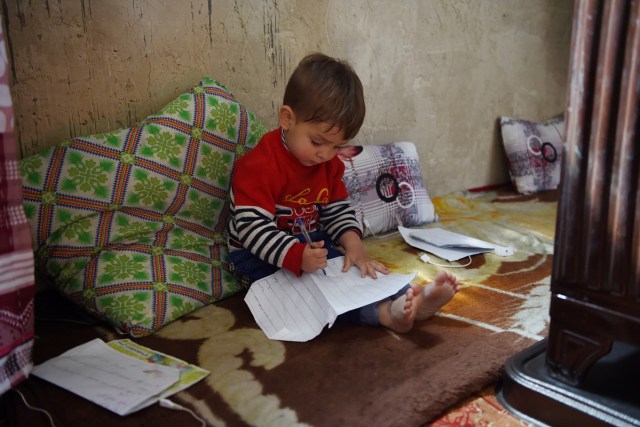 This picture taken on March 16, 2018 shows Afghan toddler Donald Trump, who is aged around 18 months, playing at his home in Kabul. Donald Trump flops over his pink and white baby walker and rolls it around the unfurnished room in Kabul, blissfully unaware of the turmoil his "infidel" name is causing in the conservative Muslim country. The rosy-cheeked toddler, whose parents named him after the more famous Donald Trump in the hope of replicating his success, is at the centre of a social media firestorm after a photo of his Afghan ID papers was posted on Facebook. / AFP PHOTO / Wakil KOHSAR / TO GO WITH 'AFGHANISTAN-PEOPLE-RELIGION' BY ALLISON JACKSON AND MUSHTAQ MOJADDIDI