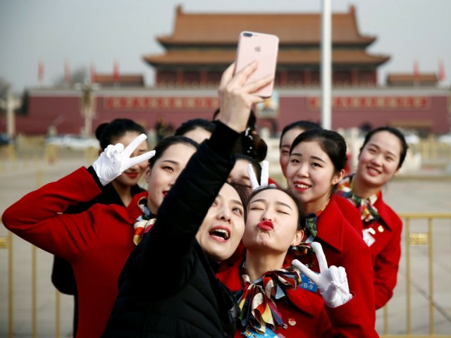 Los ujieres posan para fotos en la Plaza de Tiananmen durante la sesión de apertura de la Asamblea Popular Nacional (APN) en Beijing, China./ Foto Reuters 