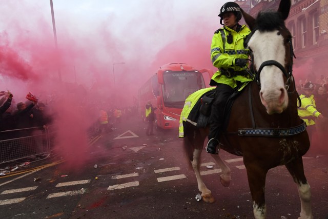 Police keep control as Liverpool players arrive by bus through smoke and beercans before the UEFA Champions League first leg quarter-final football match between Liverpool and Manchester City, at Anfield stadium in Liverpool, north west England on April 4, 2018. / AFP PHOTO / Paul ELLIS