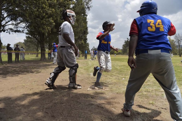 Venezuelan immigrants play softball during the inauguration of the Pichincha League Softball Championship, at Parque Bicentenario, in Quito on March 18, 2018. The increase in the number of Venezuelan immigrants in Ecuador leaded to growth of the softball league from four to 16 teams in the last years, with some 450 players in total. / AFP PHOTO / Rodrigo BUENDIA / TO GO WITH AFP STORY BY PAOLA LOPEZ