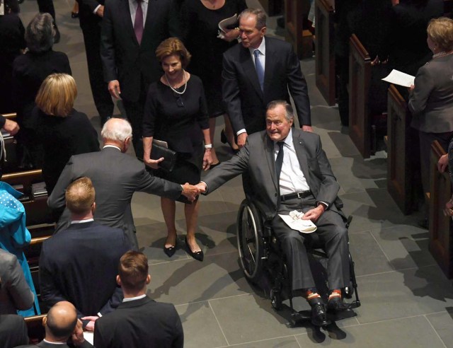 Former US President George H.W. Bush exits the funeral of his wife First Lady Barbara Bush, followed by his daughter-in-law former First Lady Laura Bush and former President George W. Bush at St. Martin's Episcopal Church in Houston, Texas, on April 21, 2018. / AFP PHOTO / POOL / Jack Gruber