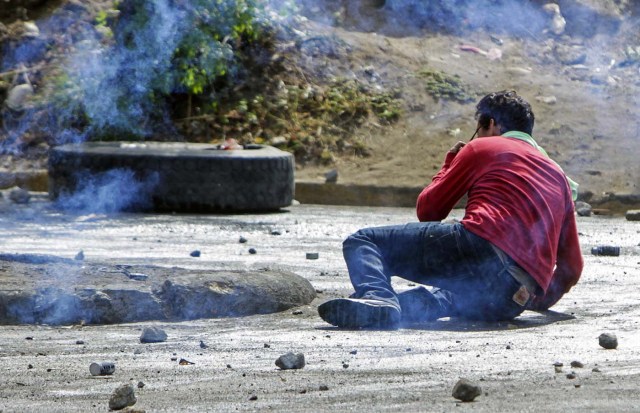 A student falls after receiving a shot from a rubber bullet during protests against government's reforms in the Institute of Social Security (INSS) in Managua on April 21, 2018. Violent protests against a proposed change to Nicaragua's pension system have left at least 10 people dead over two days, the government said Friday. In the biggest protests in President Daniel Ortega's 11 years in office in this poor Central American country, people are angry over the plan because workers and employers would have to chip in more toward the retirement system. / AFP PHOTO / INTI OCON