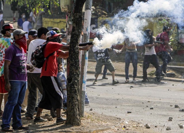 Students clash with riot police agents close to Nicaragua's Technical College during protests against government's reforms in the Institute of Social Security (INSS) in Managua on April 21, 2018. Violent protests against a proposed change to Nicaragua's pension system have left at least 10 people dead over two days, the government said Friday. In the biggest protests in President Daniel Ortega's 11 years in office in this poor Central American country, people are angry over the plan because workers and employers would have to chip in more toward the retirement system. / AFP PHOTO / INTI OCON