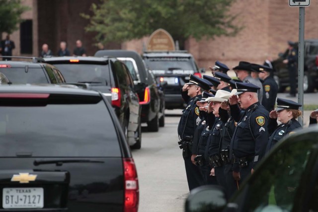 HOUSTON, TX - APRIL 21: Police salute as the remains of former first lady Barbara Bush leave St. Martin's Episcopal Church following her funeral service on April 21, 2018 in Houston, Texas. Bush, wife of former president George H. W. Bush and mother of former president George W. Bush, died at her home in Houston on April 17 at the age of 92. Scott Olson/Getty Images/AFP