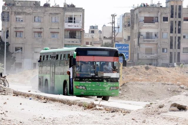 Un autobús en el que viajan rebeldes y familiares abandona al barrio asediado de Al Waer, en la ciudad de Homs, Siria. EFE/Archivo