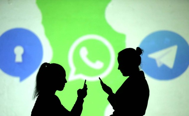 REFILE - CLARIFYING CAPTION Silhouettes of mobile users are seen next to logos of social media apps Signal, Whatsapp and Telegram projected on a screen in this picture illustration taken March 28, 2018. REUTERS/Dado Ruvic/Illustration