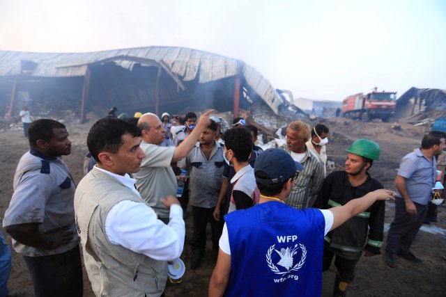 Los trabajadores humanitarios inspeccionan un almacén del Programa Mundial de Alimentos un día después de que el fuego lo envolvió en la ciudad portuaria de Hodeida, Yemen, el 1 de abril de 2018. REUTERS / Abduljabbar Zeyad