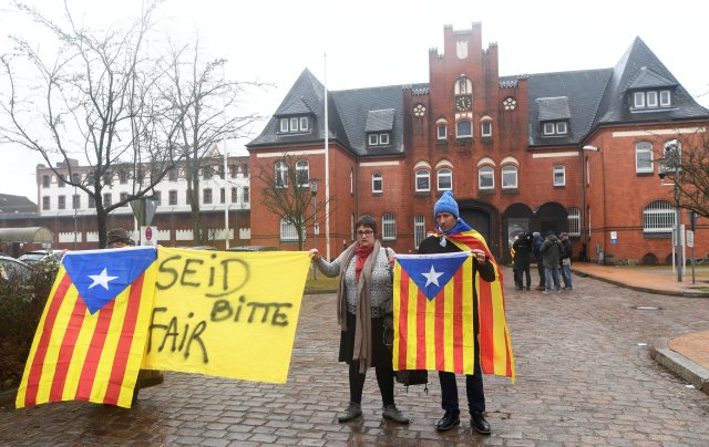 People hold a poster and Estelada (Catalan separatist flag) in protest to support the release of former Catalan regional president Carles Puigdemont in front of the prison in Neumuenster, Germany, April 3, 2018.  The poster reads "Be fair please"    REUTERS/Fabian Bimmer