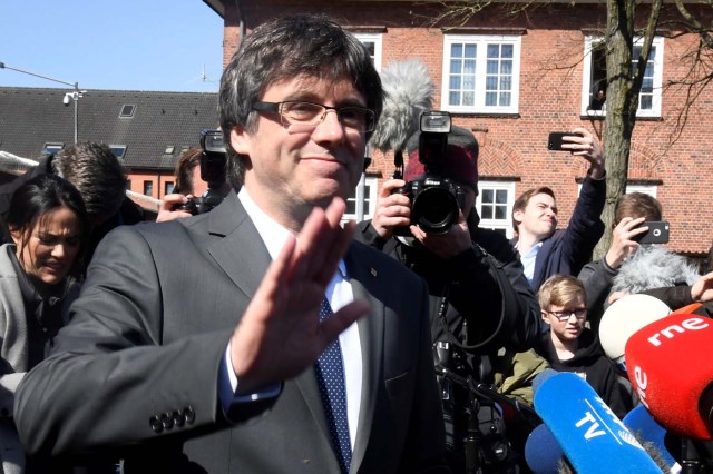 Catalonia's former leader Carles Puigdemont waves to the media as he leaves the prison in Neumuenster, Germany, April 6, 2018. A German court on Thursday rejected an extradition request for Puigdemont on the charge of rebellion for his role in the campaign for the region's independence. REUTERS/Fabian Bimmer