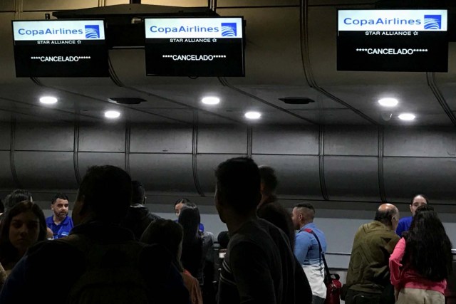 Screens that read "Cancelled" hang above counters of Copa Airlines at the Simon Bolivar airport in Caracas, Venezuela April 6, 2018. REUTERS/Marco Bello