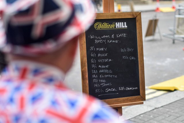 A man dressed in a Union Jack suit looks at the names and betting odds for the third royal baby of Britain's Prince William and Catherine, Duchess of Cambridge, on a board outside the Lindo Wing St Mary's Hospital in west London, Britain, April 13, 2018. REUTERS/Peter Summers