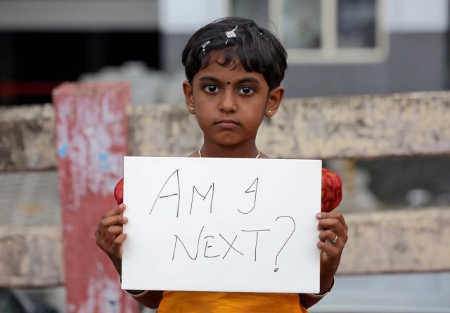 REFILE - CORRECTING TYPO A girl holds a placard during a protest against the rape of an eight-year-old girl in Kathua, near Jammu, in Kochi, India April 15, 2018. REUTERS/Sivaram V