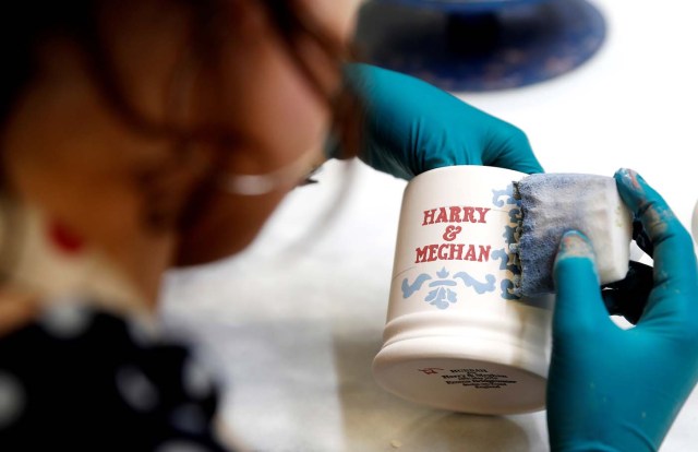 A worker prints a design onto a souvenir mug to commemorate the wedding of Britain's Prince Harry and Meghan Markle at the Emma Bridgewater Factory, in Hanley, Stoke-on-Trent, Britain March 28, 2018. Picture taken March 28, 2018. REUTERS/Carl Recine.