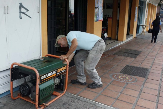 A man turns off a generator as power was restored after a blackout in San Cristobal, Venezuela, April 20, 2018. REUTERS/Carlos Eduardo Ramirez