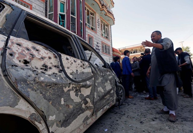 En la imagen, hombres afganos inspeccionan el lugar de un atentado suicida con bomba en Kabul, Afganistán, el 22 de abril de 2018. REUTERS/Omar Sobhani