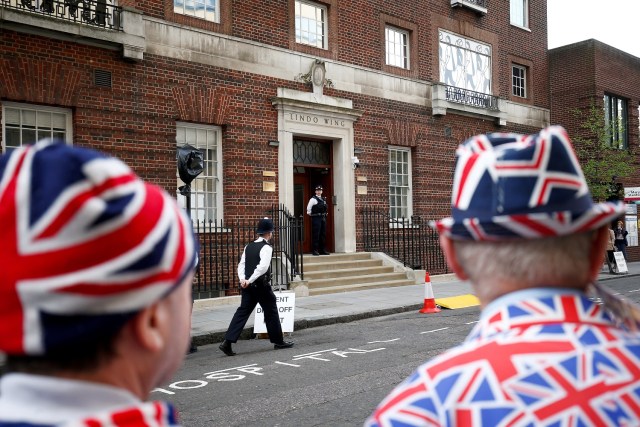 Supporters of the royal family stand outside the Lindo Wing of St Mary's Hospital after Britain's Catherine, the Duchess of Cambridge, was admitted after going into labour ahead of the birth of her third child, in London, April 23, 2018. REUTERS/Henry Nicholls