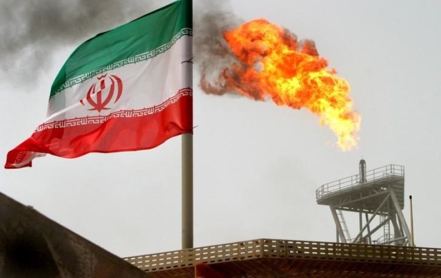 En la imagen de archivo una llamarada de gas en una plataforma de producción de petróleo en los campos petroleros de Soroush se ve junto con una bandera iraní en el Golfo Pérsico, Irán, el 25 de julio de 2005. REUTERS / Raheb Homavandi