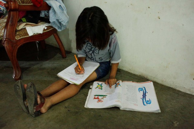 Gilari Martínez, nieta de Carmen Peñaloza, escribe en un cuaderno en su casa de San Cristóbal, Venezuela el 5 de abril de 2018. Foto tomada el 5 de abril de 2018. REUTERS / Carlos Eduardo Ramírez