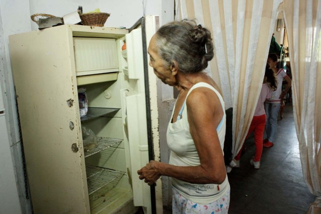 Carmen Peñaloza mira la nevera en su casa de San Cristóbal, Venezuela, 22 de febrero de 2018. Foto tomada el 22 de febrero de 2018. REUTERS / Carlos Eduardo Ramírez