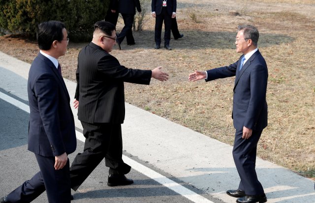 El presidente surcoreano Moon Jae-in y el líder norcoreano Kim Jong Un estrechan la mano en la aldea de tregua de Panmunjom dentro de la zona desmilitarizada que separa las dos Coreas, Corea del Sur, el 27 de abril de 2018. Korea Summit Press Pool / Pool via Reuters