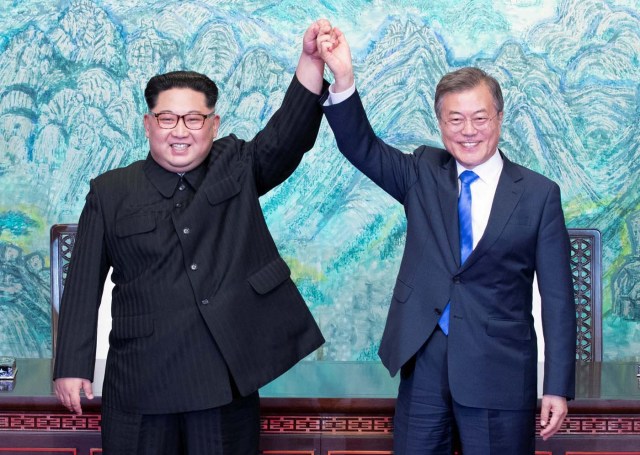 South Korean President Moon Jae-in and North Korean leader Kim Jong Un raise their hands at the truce village of Panmunjom inside the demilitarized zone separating the two Koreas, South Korea, April 27, 2018. Korea Summit Press Pool/Pool via Reuters
