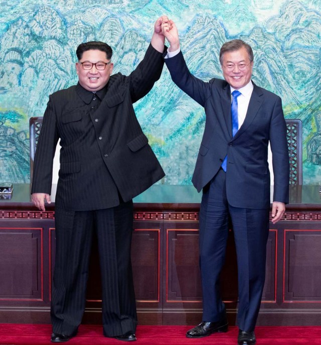 South Korean President Moon Jae-in and North Korean leader Kim Jong Un raise their hands at the truce village of Panmunjom inside the demilitarized zone separating the two Koreas, South Korea, April 27, 2018. Korea Summit Press Pool/Pool via Reuters