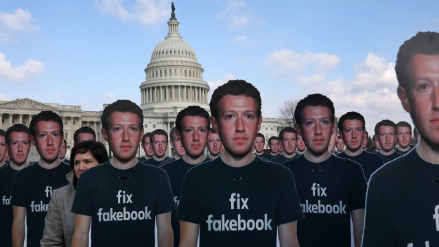 La directora de la campaña de Avaaz.org Nell Greenberg, (L), camina entre docenas de recortes de cartón del CEO de Facebook, Mark Zuckerberg, mientras realiza una protesta afuera del edificio del Capitolio de los Estados Unidos en Washington, EE.UU., 10 de abril de 2018