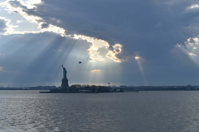 View of the Statue of Liberty during the sunset, in New York City, on April 28, 2018. / AFP PHOTO / HECTOR RETAMAL