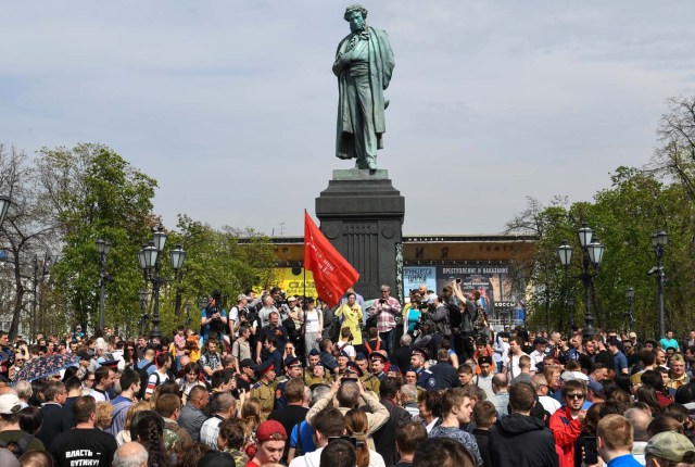 Pro-Kremlin activists gather around a monument of poet Alexander Pushkin some 30 minutes before the start of an unauthorized anti-Putin rally called by opposition leader Alexei Navalny on May 5, 2018 in Moscow, two days ahead of Vladimir Putin's inauguration for a fourth Kremlin term. / AFP PHOTO / Kirill KUDRYAVTSEV