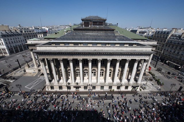 People demonstrate along a main thoroughfare, past the former Paris stock exchange, Bourse de Paris or Palais Brongniart, in the French capital Paris during a rally dubbed a "Party for Macron" against the policies of the French president on the first anniversary of his election, on May 5, 2018. Thousands of people demonstrated in central Paris amid a heavy police presence to protest against President Emmanuel Macron's sweeping reforms, a year after he came to office. / AFP PHOTO / Olivier MORIN