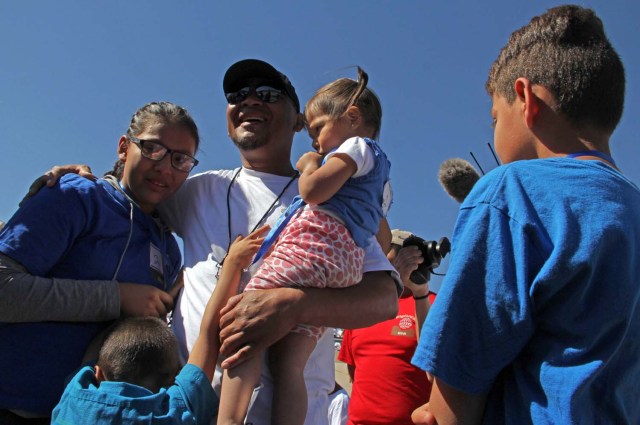 Ivan Castaneda (40), a former Mexican soldier deported two weeks ago from the United States, embraces his family at the bank of the Rio Grande during the event called "Abrazos No Muros" (Hugs, not walls) promoted by the Border Network of Human Rights organization in the border line between El Paso, Texas, United States and Ciudad Juarez, Chihuahua state, Mexico on May 12, 2018. Castaneda was denied a political asylum he requested in 2012 to flee violence in Ciudad Juarez, while his wife, mother and five children remain in Denver, Colorado, United States. / AFP PHOTO / HERIKA MARTINEZ