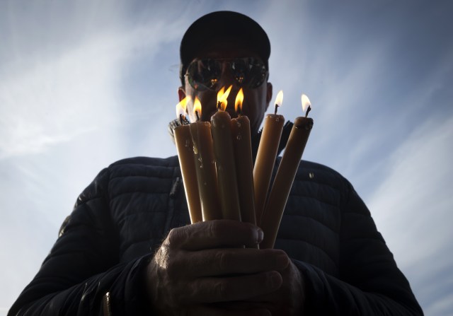 Un peregrino enciende velas en el santuario de Fátima el 13 de mayo de 2018. Miles de peregrinos se reunieron en el Santuario de Fátima para celebrar el aniversario del milagro de Fátima cuando tres niños pastores afirmaron haber visto a la Virgen María en mayo de 1917. / AFP PHOTO / MIGUEL RIOPA