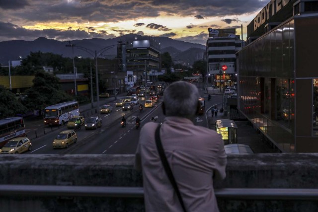 Venezuelan Carlos Figueroa watches the sunset in a street in Medellin, Colombia, on April 18, 2018. Exiled Venezuelans have no expectations of the presidential election taking place next May 20 in their home country. / AFP PHOTO / JOAQUIN SARMIENTO