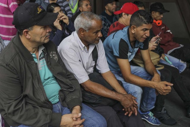Venezuelan Carlos Figueroa (2nd L) waits to be registered as a migrant at the "Personeria" in Medellin, Colombia, on April 16, 2018. Exiled Venezuelans have no expectations of the presidential election taking place next May 20 in their home country. / AFP PHOTO / JOAQUIN SARMIENTO