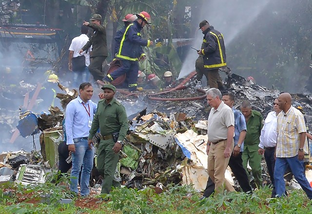 Cuban President Miguel Diaz-Canel (2-R, in khaki) is pictured at the site of the accident after a Cubana de Aviacion aircraft crashed after taking off from Havana's Jose Marti airport on May 18, 2018. A Cuban state airways passenger plane with 104 passengers on board crashed on shortly after taking off from Havana's airport, state media reported. The Boeing 737 operated by Cubana de Aviacion crashed "near the international airport," state agency Prensa Latina reported. Airport sources said the jetliner was heading from the capital to the eastern city of Holguin.  / AFP PHOTO / Adalberto ROQUE