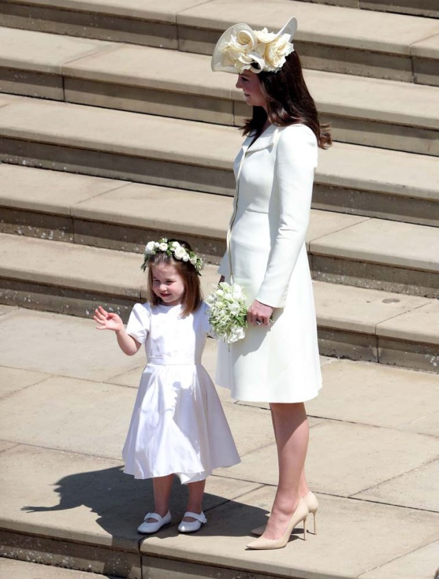Princess Charlotte of Cambridge (L) waves holding the hand of her mother Britain's Catherine, Duchess of Cambridge, (R) after attending the wedding ceremony of Britain's Prince Harry, Duke of Sussex and US actress Meghan Markle at St George's Chapel, Windsor Castle, in Windsor, on May 19, 2018. / AFP PHOTO / POOL / Andrew Matthews