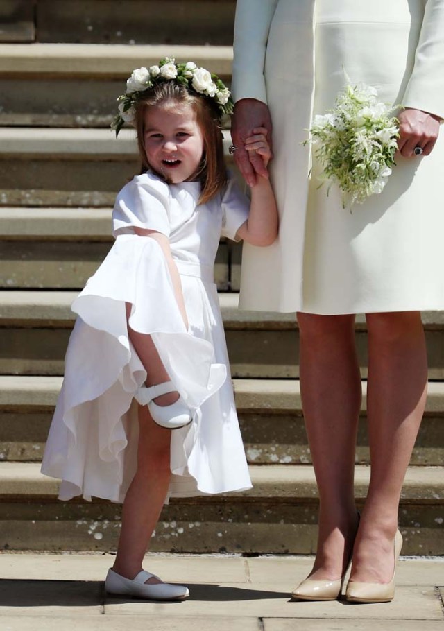 Princess Charlotte of Cambridge (L) stands on the steps holding the hand of her mother Britain's Catherine, Duchess of Cambridge, (R) after attending the wedding ceremony of Britain's Prince Harry, Duke of Sussex and US actress Meghan Markle at St George's Chapel, Windsor Castle, in Windsor, on May 19, 2018. / AFP PHOTO / POOL / Jane Barlow