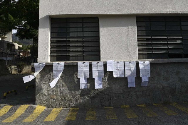 List of voters are seen at an empty polling station during the presidential elections in Caracas on May 20, 2018 Venezuelans, reeling under a devastating economic crisis, began voting Sunday in an election boycotted by the opposition and condemned by much of the international community but expected to hand deeply unpopular President Nicolas Maduro a new mandate / Los listados de votantes AFP PHOTO / Carlos Becerra