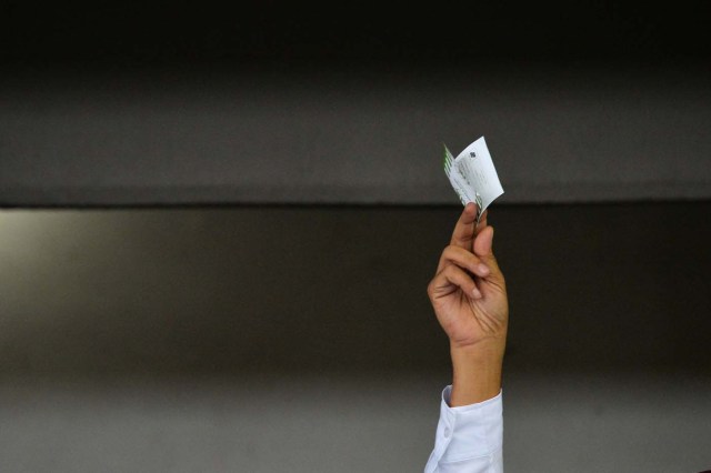 Venezuelan opposition presidential candidate Henri Falcon shows his vote moments before casting his ballot in Barquisimeto, on May 20, 2018. Venezuelans, reeling under a devastating economic crisis, began voting Sunday in an election boycotted by the opposition and condemned by much of the international community but expected to hand deeply unpopular President Nicolas Maduro a new mandate / AFP PHOTO / Luis Robayo