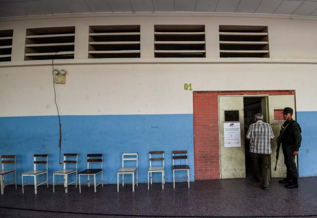 A Venezuelan men enters an empty polling station during the presidential elections in Caracas on May 20, 2018 Venezuelans, reeling under a devastating economic crisis, began voting Sunday in an election boycotted by the opposition and condemned by much of the international community but expected to hand deeply unpopular President Nicolas Maduro a new mandate / AFP PHOTO / Juan BARRETO