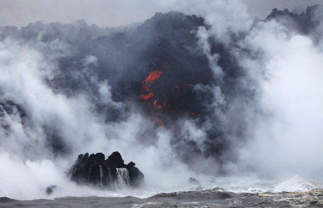 PAHOA, HI - 20 DE MAYO: Una pluma de vapor se eleva cuando la lava (C) entra en el Océano Pacífico, después de fluir al agua de una grieta del volcán de Kilauea, en la isla grande de Hawaii el 20 de mayo de 2018 cerca de Pahoa, Hawaii. Los funcionarios están preocupados de que 'holgazanear', un producto peligroso producido cuando la lava caliente golpea el agua fría del océano, afectará a los residentes. Laze, una combinación de palabras de lava y neblina, contiene vapor de ácido clorhídrico junto con partículas de vidrio volcánico. Mario Tama / Getty Images / AFP