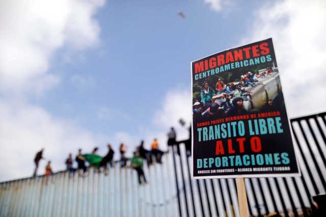 Un cartel exigiendo el tránsito libre de migrantes centroamericanos es fotografiado delante de la cerca fronteriza entre México y Estados Unidos, donde activistas se sientan como protesta antes de solicitar asilo en Estados Unidos, en Tijuana, México, 29 de abril de 2018. REUTERS/Edgard Garrido