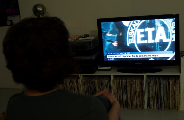 Una mujer ve un programa de noticias que anuncia la disolución de los separatistas vascos armados ETA en Guernica, España, el 18 de abril de 2018. REUTERS / Vincent West