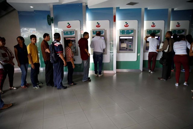 People queue to use the automated teller machines (ATM) at a Banesco bank branch in Caracas, Venezuela May 4, 2018. REUTERS/Carlos Garcia Rawlins